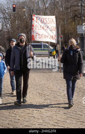 Partecipanti con segno „Russia si prega di fermare Putin e la guerra“. Il 12 marzo 2022, centinaia di persone si sono riunite nella Koenigsplatz di Monaco di Baviera, in Germania, per dimostrare la loro solidarietà con l'Ucraina. I manifestanti hanno chiesto il ritiro immediato delle truppe russe, una soluzione politica al conflitto, il sostegno del governo tedesco e sanzioni immediate contro la Russia. (Foto di Alexander Pohl/Sipa USA) Foto Stock