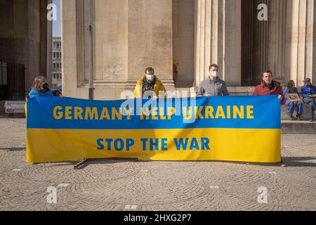 I partecipanti con banner „Germania aiutano l'Ucraina, fermare la guerra“. Il 12 marzo 2022, centinaia di persone si sono riunite nella Koenigsplatz di Monaco di Baviera, in Germania, per dimostrare la loro solidarietà con l'Ucraina. I manifestanti hanno chiesto il ritiro immediato delle truppe russe, una soluzione politica al conflitto, il sostegno del governo tedesco e sanzioni immediate contro la Russia. (Foto di Alexander Pohl/Sipa USA) Foto Stock