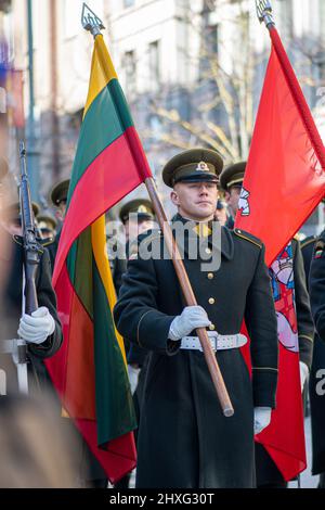 Soldato in uniformi ufficiali che marciano per le strade della capitale Vilnius, Lituania con bandiere nazionali, 11 marzo Independence Day, primo piano Foto Stock