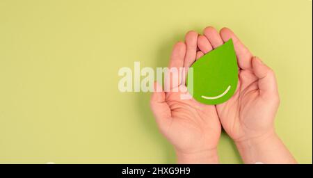 Tenere una goccia verde, olio d'oliva, biocombustibile alternativo, risorse di riciclaggio, stile di vita sostenibile, concetto di ecologia Foto Stock