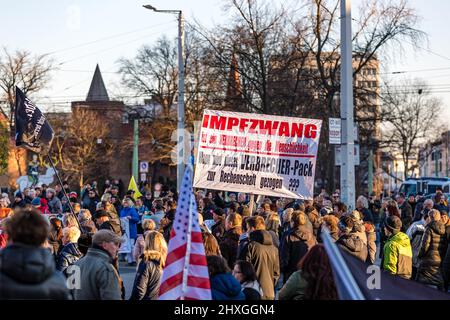 Cottbus, Germania. 12th Mar 2022. I partecipanti hanno un cartello con la scritta "la vaccinazione obbligatoria è un crimine contro l'umanità. Quando sarà ritenuto responsabile questo pacchetto di criminali??”, in una manifestazione contro le misure federali e statali di Corona. Credit: Frank Hammerschmidt/dpa/Alamy Live News Foto Stock