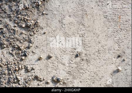 Sabbia e ghiaia su pavimento in cemento armato. Adatto per sfondo. Foto Stock