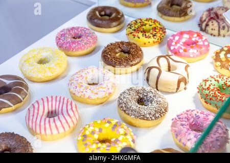 Diverse ciambelle sono esposte in una pasticceria Foto Stock