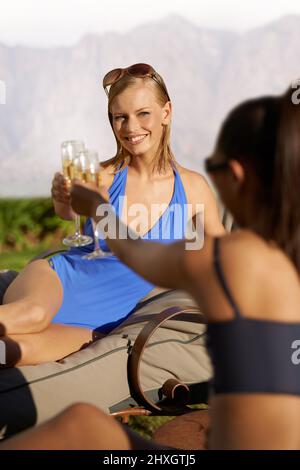 Grazie. Immagine ritagliata di due donne in costume da bagno che bevono bevande alcoliche. Foto Stock