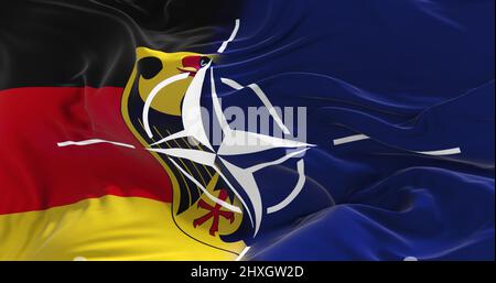 Minsk, Bielorussia - Maggio, 2021: Bandiera della Germania e della NATO a cielo nuvoloso sfondo al tramonto. Collaborazione patriota concetto. Trattato Nord Atlantico Organiza Foto Stock