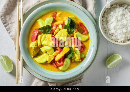 Curry giallo fresco e piccante con foglie di kaffir, latte di cocco e pollo curry giallo con riso e pollo. Foto Stock