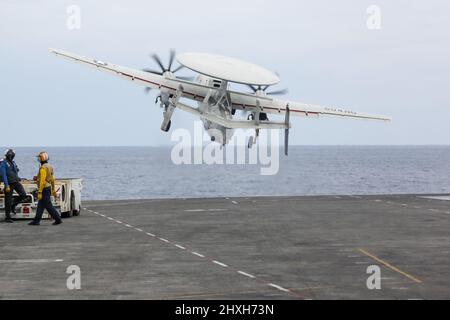 PHILIPPINE SEA (11 marzo 2022) un e-2D Hawkeye, assegnato ai "Wallbangers" della Carrier Airborne Early Warning Squadron (VAW) 117, lancia dal ponte di volo della portaerei di classe Nimitz USS Abraham Lincoln (CVN 72). Abraham Lincoln Strike Group è in fase di implementazione pianificata nell'area delle operazioni della flotta USA 7th per migliorare l'interoperabilità attraverso alleanze e partnership, fungendo da forza di risposta pronta a supportare una regione indopacifica libera e aperta. (STATI UNITI Foto Navy di SMass Communication Specialist Seaman Aleksandr Freutel) Foto Stock