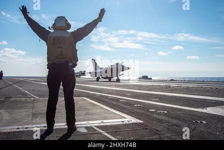 220311-N-ZE328-1409 IONIAN SEA (MAR. 11, 2022) Aviation Boatswain's Mate (Handling) 3rd Class Kallista Zimmerman, di Cedar City, Utah, dirige il pilota di un francese Rafale F-3R sul ponte di volo della portaerei di classe Nimitz USS Harry S. Truman (CVN 75), 11 marzo 2022. Il Gruppo Harry S. Truman Carrier Strike è in fase di implementazione nell'area della Sixth Fleet degli Stati Uniti a sostegno degli interessi degli Stati Uniti, degli alleati e dei partner in Europa e Africa. (STATI UNITI Foto Navy di Mass Communication Specialist 2nd Classe Kelsey Trinh) Foto Stock