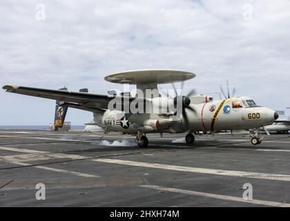 PHILIPPINE SEA (11 marzo 2022) un e-2D Hawkeye, assegnato ai "Wallbangers" della Carrier Airborne Early Warning Squadron (VAW) 117, fa un atterraggio arrestato sul ponte di volo della portaerei di classe Nimitz USS Abraham Lincoln (CVN 72). Abraham Lincoln Strike Group è in fase di implementazione pianificata nell'area delle operazioni della flotta USA 7th per migliorare l'interoperabilità attraverso alleanze e partnership, fungendo da forza di risposta pronta a supportare una regione indopacifica libera e aperta. (STATI UNITI Foto Navy di SMass Communication Specialist Seaman Aleksandr Freutel) Foto Stock