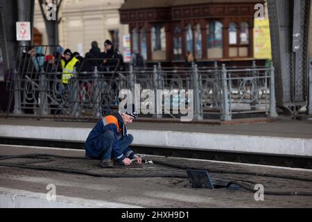 Lviv, Ucraina. 12th Mar 2022. Un ingegnere ha visto lavorare al binario della stazione ferroviaria di Lviv. Lviv, la più grande città dell'Ucraina occidentale, è ora diventata un centro di transito per donne e bambini in fuga verso l'Europa, mentre gli uomini ritornano e si recano nell'Ucraina orientale per difendere il paese. (Foto di Hesther ng/SOPA Images/Sipa USA) Credit: Sipa USA/Alamy Live News Foto Stock