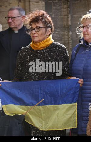 Peterborough, Regno Unito. 12th Mar 2022. I visitatori si riuniscono alla cerimonia di preghiera una bandiera Ucraina. In un momento in cui l'Ucraina è sotto attacco da parte della Russia di Vladimir Putin, i lituani celebrano la Giornata dell'indipendenza per il restauro nella Cattedrale di Peterborough. Essi sostengono l'Ucraina e detengono le bandiere e i nastri ucraini. La Lituania ha riconquistato la propria libertà dall'Unione Sovietica il 11th 1990 marzo. Una breve preghiera e un minuto di silenzio sono stati tenuti per i caduti difensori della libertà. (Foto di Martin Pope/SOPA Images/Sipa USA) Credit: Sipa USA/Alamy Live News Foto Stock