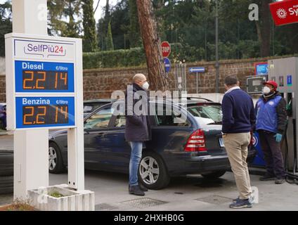 Roma, Italia. 12th Mar 2022. Il 12 marzo 2022 un membro del personale alimenta un veicolo in una stazione di servizio a Roma (Italia). Il prezzo del carburante in Italia ha superato di recente i 2,00 euro al litro. Credit: Jin Mamengni/Xinhua/Alamy Live News Foto Stock