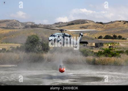 US Navy MH60S riempie il Bambi Bucket a bordo di MCB Camp Pendleton; California durante gli esercizi antincendio con Cal Fire. Foto Stock