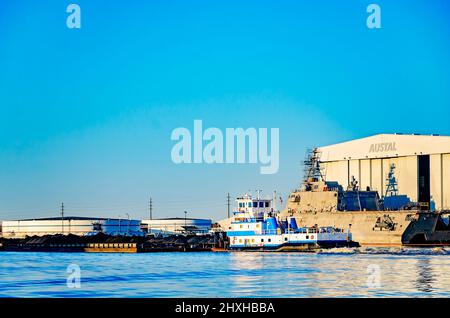 Il rimorchiatore Alice Parker spinge una chiatta di carbone oltre Austal USA mentre viaggia sul fiume Mobile, 10 marzo 2022, a Mobile, Alabama. Foto Stock