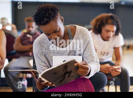 Immerso in un mag danzante. Shot di una giovane ballerina femminile che legge una rivista danzante in attesa della sua audizione. Foto Stock
