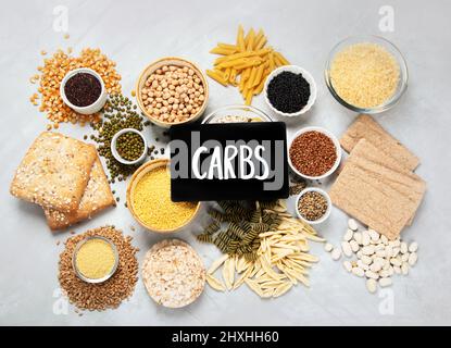 Migliori fonti di carbs su sfondo grigio chiaro. Concetto di cibo sano. Vista dall'alto, piatto Foto Stock