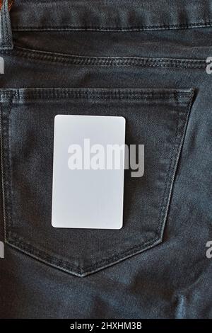 La parte superiore di vecchi jeans neri indossati con tasche e un tag bianco per i vestiti Foto Stock