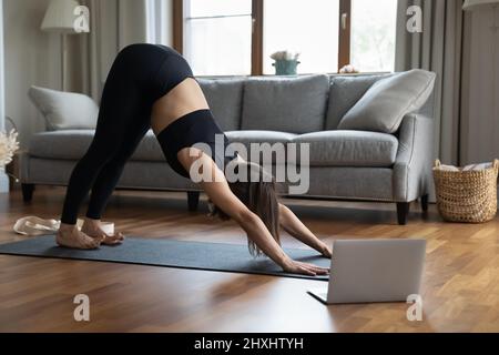 Yogini trainer conduce la classe virtuale online da casa in quarantena Foto Stock