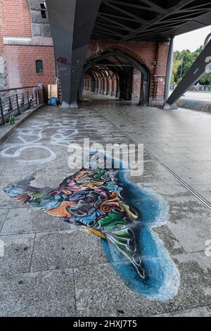 Murale su un marciapiede del ponte Oberbaum (Oberbaumbrucke) sul fiume Sprea nella città di Berlino, Germania. Foto Stock