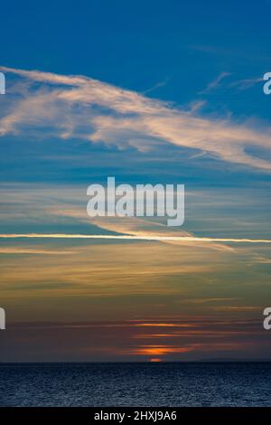 Il sole che scompare dietro una nuvola copre e illumina le nuvole con il cielo blu Foto Stock