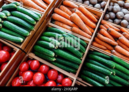 Pomodori, cetrioli, carote e patate sono disposti sul bancone della fiera del paese. Cibo rurale e concetto di agricoltura. Foto Stock