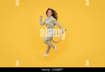 happy energico bambino salto in abbigliamento sportivo con racchetta squash running al successo, stamina. Foto Stock