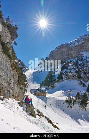 Donna escursione nel paesaggio innevato della catena montuosa Alpstein vicino ad Appenzell, Svizzera Foto Stock