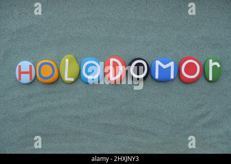 Holodomor, morte per fame, in ucraino, testo di lettere in pietra multicolore composto su sabbia verde Foto Stock