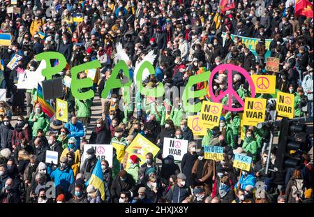 Amburgo, Germania. 13th Mar 2022. I partecipanti a una manifestazione contro il conflitto ucraino si levano in piedi sul Jungfernstieg e tengono la parola 'Pace?. Credit: Daniel Bockwoldt/dpa/Alamy Live News Foto Stock