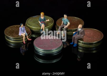 Miniatura 4 persone sedute su rubli russi pile di monete . Riunione o discussione usando come concetto di affari. Foto Stock