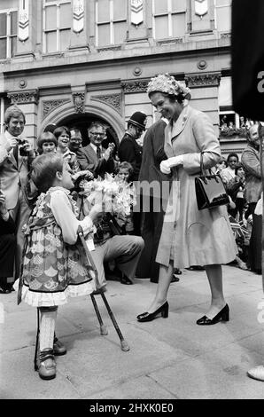 La Regina Elisabetta II visitò Birmingham durante il suo tour Silver Jubilee. West Midlands. La regina riceve un bouquet di fiori da un bambino. 27th luglio 1977. Foto Stock