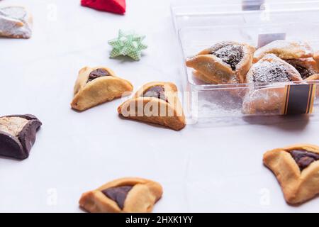 Purim Celebration Concept, festa del carnevale ebraico. Biscotti tradizionali di hamantaschen su tavola bianca di legno. Foto di alta qualità Foto Stock