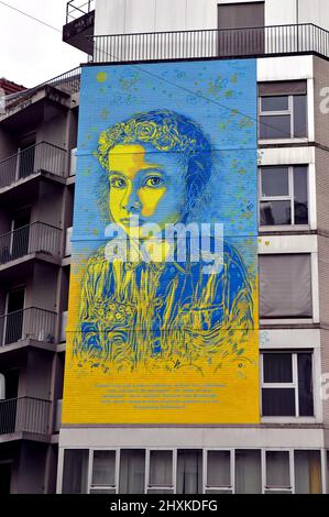 Parigi, Francia. 13th Mar 2022. Murale dell'artista francese C215 che rappresenta una bambina che indossa una corona slava di fiori nei colori della bandiera Ucraina sulla facciata di un edificio nel 13th circondario di Parigi. Parigi, Francia il 13 marzo 2022. Photo by Karim Ait Adjedjou/Avenir Pictures/ABACAPRESS.COM Credi Credit: Abaca Press/Alamy Live News Foto Stock