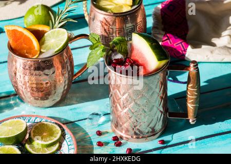 Un cocktail frosty guarnito con cocomero e melograno arils in sole luminoso. Foto Stock