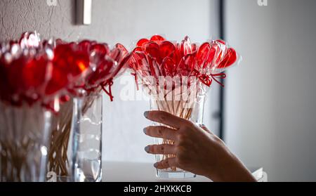 Lollipops rosso a forma di cuore sul bancone di un negozio di caramelle. Foto Stock