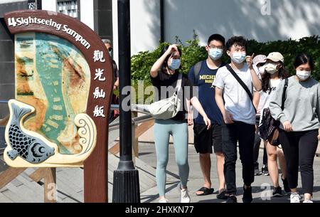 (220314) -- HONG KONG, 14 marzo 2022 (Xinhua) -- la gente che indossa le maschere cammina sulla strada nella Cina meridionale di Hong Kong, 13 marzo 2022. Domenica, Hong Kong ha registrato 13.335 nuovi casi COVID-19 mediante test sugli acidi nucleici, e 19.095 ulteriori casi positivi attraverso test antigenici rapidi auto-riportati, dati ufficiali hanno mostrato. (Xinhua/lo Ping Fai) Foto Stock