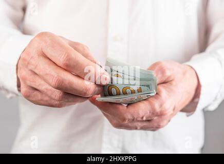 Mani closeup contare 100 dollari US fatture, carta valuta. Concetto di risparmio. Foto Stock