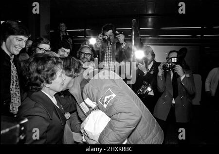 James Hunt, il nuovo campione del mondo di corse automobilistiche, ha ricevuto il benvenuto di un eroe quando ha volato all'aeroporto di Heathrow questa mattina dal Giappone. Il pilota di Formula uno della McLaren di 29 anni è stato accolto dalla maggior parte della sua famiglia e fidanzata Jane Birbeck. L'immagine mostra il saluto di James e baciare la sua madre felice, sue Hunt. Foto scattata 26th October1976 Foto Stock