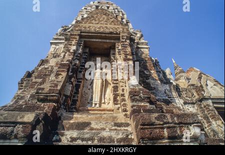 Una statua al Prang di Wat Phra si Sanphet tempio in Ayutthaya. L'ex capitale del Siam fu conquistata da un esercito birmano nel 1767 e successivamente saccheggiata e parzialmente distrutta. C'è ancora un senso dell'antico splendore del grande tempio. Foto Stock