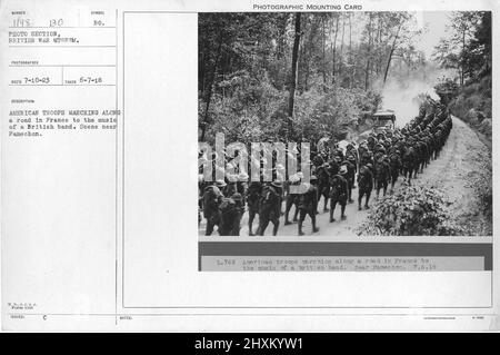 Truppe americane marciando lungo una strada in Francia alla musica di una band britannica. Scena vicino a Famechon. Collezione di fotografie della prima Guerra Mondiale, 1914-1918 che raffigurano le attività militari delle forze armate britanniche e di altre nazioni e del personale durante la prima Guerra Mondiale Foto Stock