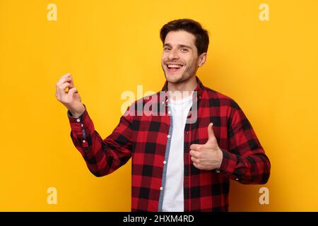 Uomo eccitato che tiene qualcosa in mano mostrando come Foto Stock