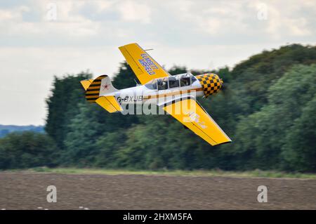 Yakovlev Yak-52 aereo aerobatico che vola basso dopo il decollo a Elmsett Airfield per effettuare l'aerobica ad un'esposizione aerea Foto Stock