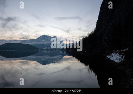 Sole pomeridiano visto da Seewiese con nebbia che si innalza dal lago e dalla montagna di Sarstein sullo sfondo Foto Stock