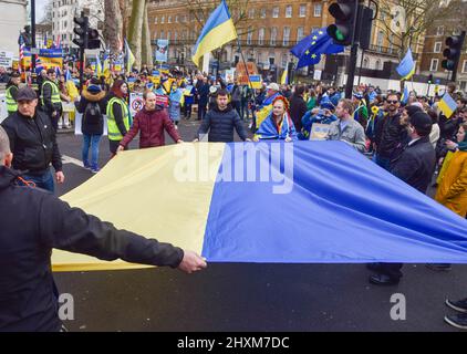 Londra, Regno Unito. 13th marzo 2022. I manifestanti detengono una grande bandiera Ucraina. Migliaia di persone si sono radunate fuori Downing Street per la 19th giornata consecutiva di proteste a sostegno dell'Ucraina mentre la Russia continua il suo attacco. Credit: Vuk Valcic/Alamy Live News Foto Stock