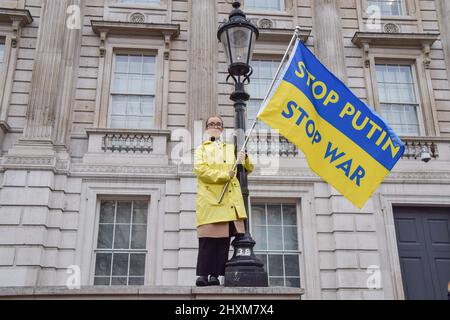 Londra, Regno Unito. 13th marzo 2022. Un manifestante detiene una bandiera Ucraina con gli slogan 'STOP Putin? E 'STOP War'. Migliaia di persone si sono radunate fuori Downing Street per la 19th giornata consecutiva di proteste a sostegno dell'Ucraina mentre la Russia continua il suo attacco. Credit: Vuk Valcic/Alamy Live News Foto Stock