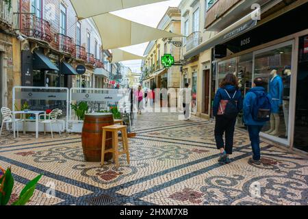 Faro, Portogallo, vista grandangolare, piccola folla di persone, turisti che camminano, lontano dalle spalle, visita le strade pedonali e il centro storico Foto Stock