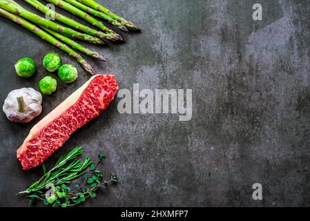 Bistecca di wagyu giapponese marmorizzata con erbe e verdure verdi Foto Stock