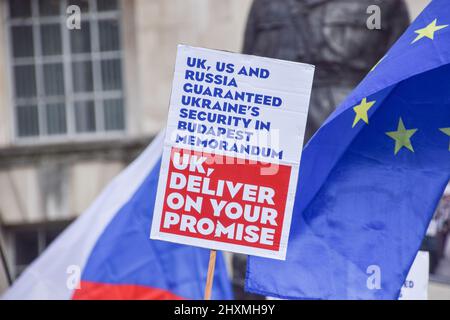 Londra, Regno Unito. 13th Mar 2022. Durante la manifestazione vengono visti un cartello con il memorandum di Budapest e una bandiera dell'UE. Migliaia di manifestanti si sono riuniti fuori Downing Street a sostegno dell'Ucraina mentre la Russia continua il suo attacco. Credit: SOPA Images Limited/Alamy Live News Foto Stock