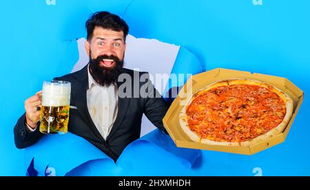 Uomo sorridente con pizza e tazza di birra. Fast food. Cucina italiana. Concetto di consegna pizza. Foto Stock