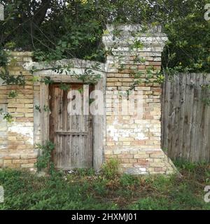 Una vecchia porta di legno all'ingresso di un antico casale abbandonato. Foto Stock